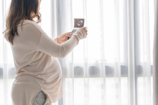 Pregnant asian woman holding  ultrasound baby Image Result from Doctor. Happy mom health care concept