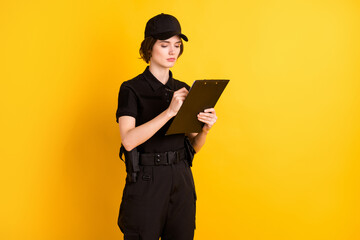 Profile portrait of pretty focused lady look arm hold pen write clipboard isolated on yellow color...