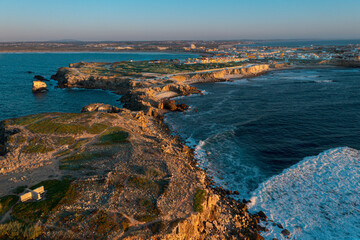 Sunset over peninsula, bay and town of Peniche, Portugal, aerial shot