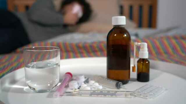 4o year old men sick at home with fever -staying in bed at home with flu and taking antibiotic medicine to treat fever after experiencing fever with thermometer  Covid-19 Coronavirus epidemic 