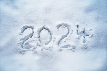 Number 2024 for the new year handwritten in the snow, calendar date and holiday symbol, copy space