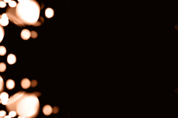 Blurry garland lights on a dark background. Festive Christmas and New Year background. Soft focus....