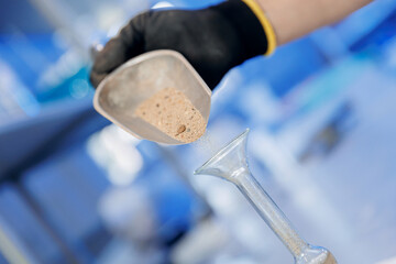 Control quality of sample sand for concrete in flask. Concept laboratory of industrial building...