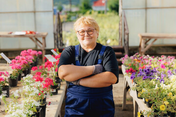 Fototapeta na wymiar Portrait senior gardener woman working in garden farm plants. Concept online shop flowers for sales