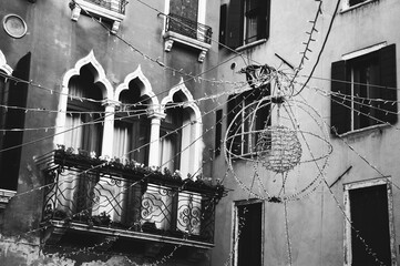 Festive illumination and old house at background. Venice, Italy. Modern and antique. Christmas celebration, carnival, holidays in Venice. Black white historic photo.