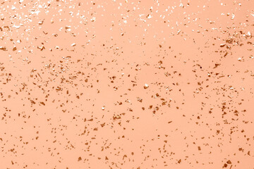 Festive background with shiny confetti. Holiday concept. Color of the Year 2024 Peach Fuzz