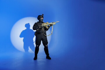 Soldier in black uniforms with weapon in studio. Concept Military warrior army tactical force to...