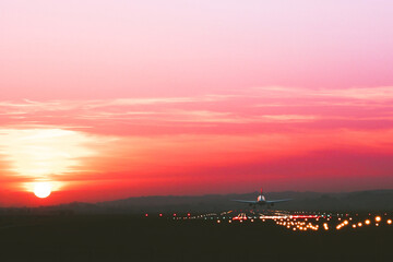 The plane takes off at an airfield on the background of sunset, toned