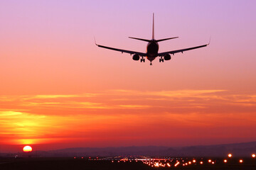 The plane lands at dusk at sunset - 692623050