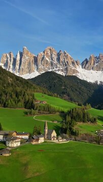 Spring landscape with shurch in Santa Magdalena village, Italian Dolomites Alps, in South Tyrol, Val di Funes, Italy. Vertical video