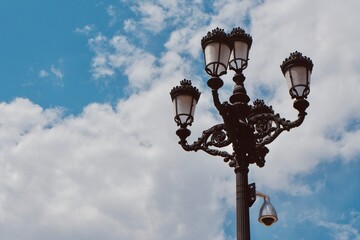Fototapeta na wymiar Vintage historical street lamp against moody skyline at daytime downtown Madrid, Spain