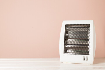 Portable electric halogen heater on wooden table