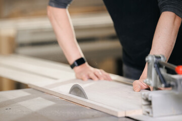 Closeup of wood cut table with electric circular saw for chipboard for furniture production. Professional carpenter cutting wooden board at sawmill