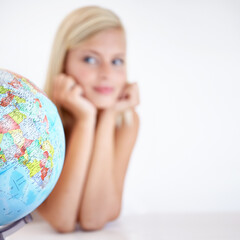 Globe, earth and a woman thinking about travel in studio on a blurry white background for freedom. Planet, map or atlas and a tourist with an idea for a holiday or vacation destination on the world