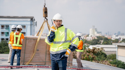 Service engineer installing solar cell on the roof of factory. Technicians working about solar panel system outdoors. Clean and Renewable energy concept.