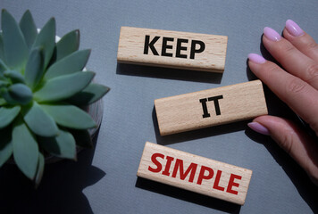 Keep it Simple symbol. Concept words Keep it Simple on wooden blocks. Businessman hand. Beautiful...