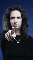 Close-Up of Stern Woman Waving Finger Saying No on blue backdrop in vertical video