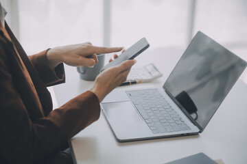 Portrait of Young Asian woman hand freelancer is working her job on computer tablet in modern office. Doing accounting analysis report real estate investment data, Financial and tax systems concept.