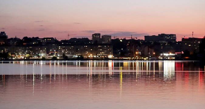 Night lights of the city reflected in the water of the Ternopil pond.