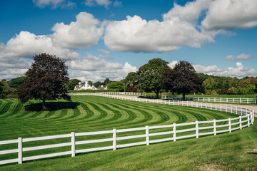 perfect american farm with a green lawn and a white fence. Farm country house in the field with...