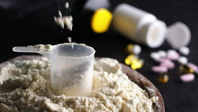 Pouring slow motion whey dry sport protein from above, supplements the food