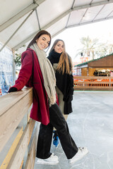 Optimistic girlfriends spending time on ice rink