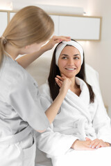 Obraz na płótnie Canvas Cosmetologist analyses the woman's skin face in beauty salon