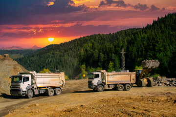 The excavator loads crushed stone in a dump truck body. Loading stones to a truck with an excavator in the forest. © serhatbozkurt