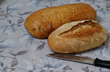 Two whole fresh loaves of bread on the table.
