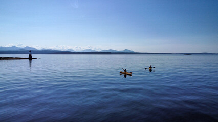 Young people kayaking in the ocean. Endless view of the Vancouver Islands. Beautiful colors