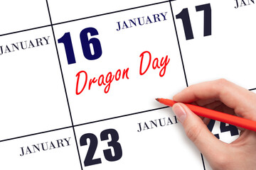 January 16. Hand writing text Dragon Day on calendar date. Save the date.