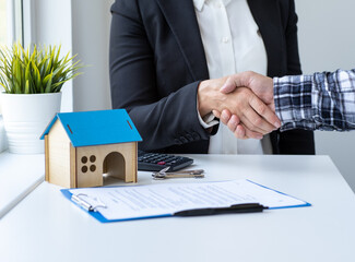 Real estate broker shaking hands with customer after signing agreement contract. Mortgage, home...
