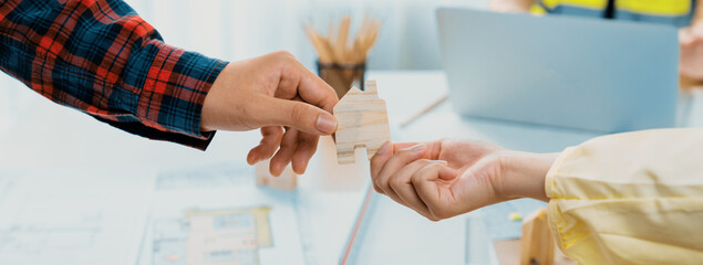 Professional engineer and architect collaborate on eco house project at meeting table with green design blueprint and architectural equipment at modern office. Focus on hand. Close up. Delineation.