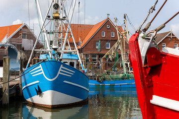 Colorful traditional old german fishing cutter boats moored Neuharlingersiel harbor Wadden sea East...