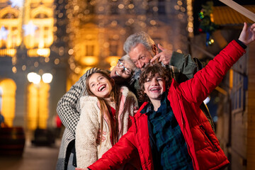 Happy smiling family celebrating Christmas outdoors.