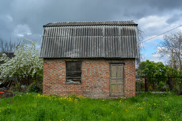 Obraz premium Abandoned brick house on a plot of land. Old house.