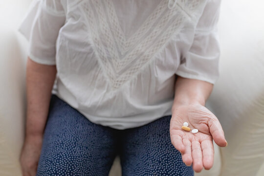 Crop woman with pills in hand