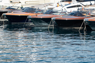 Few luxury retro motor boats in row at the famous motorboat exhibition in the principality of...