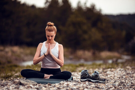 Young redhead woman meditating in nature