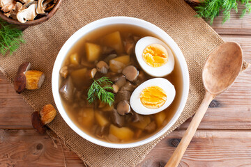 Mushroom soup with egg on rustic table, top view