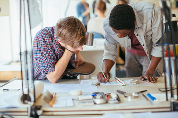 Two young male architect working in office together