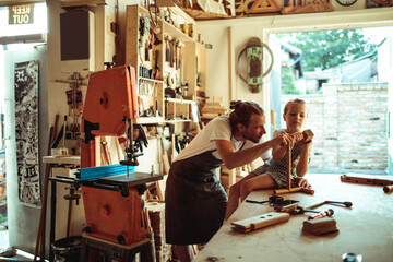 Father and Daughter Enjoying Craft Time in a Woodworking Workshop
