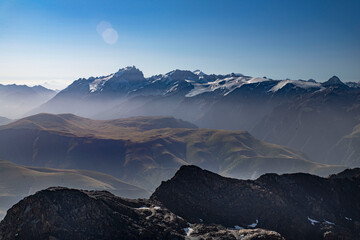 Panorama of Alpine summits in summer under the fog in France in Europe
