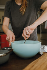 Obraz na płótnie Canvas Women's hands mixing ingredients in bowl.