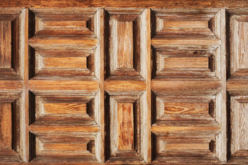 Wooden door closeup. Carpentry background. Medieval wood door. Square and rectangle shapes. Warm brown color doorway. Outdoor grunge gate. Entrance architecture.