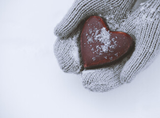 Female hands in mittens with heart, close up