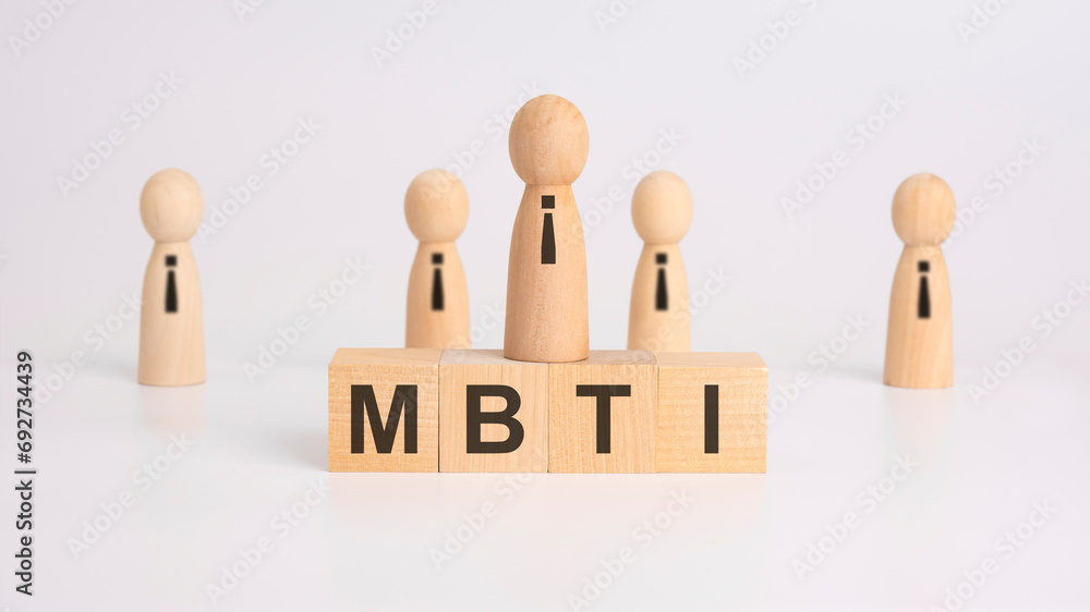 Poster wooden blocks with the letters mbti on the table. mbti - myers briggs type indicator