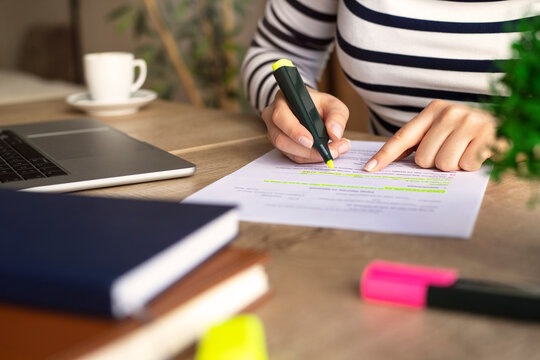 Unrecognizable businesswoman's hands highlighting important things on paper document.