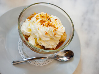Popular English dessert Banoffi in a glass, mage from cookies with bananas and cream