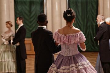 Back view of classic lady and gentleman entering ballroom in palace, copy space - obrazy, fototapety, plakaty